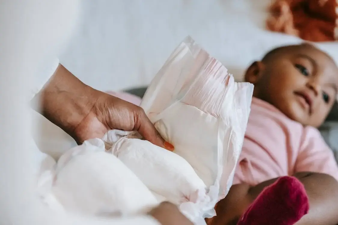 Canadian families saving money with free diaper samples Happy Canadian baby in diaper with parents researching free sample programs