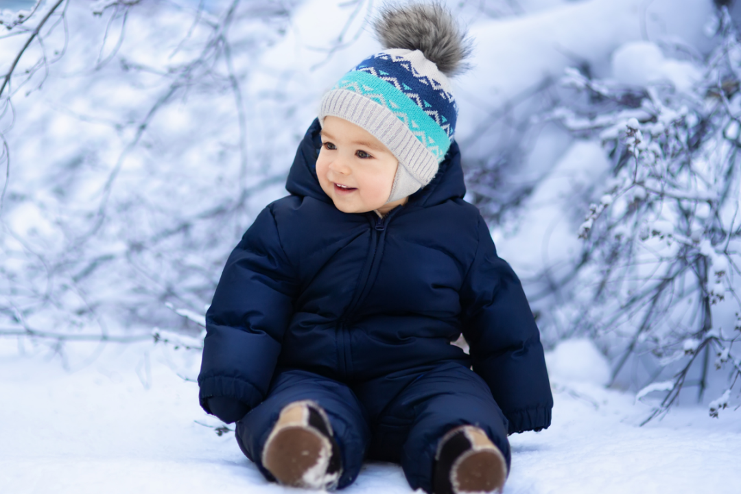 Soft winter mittens and booties laid out on a knit blanket