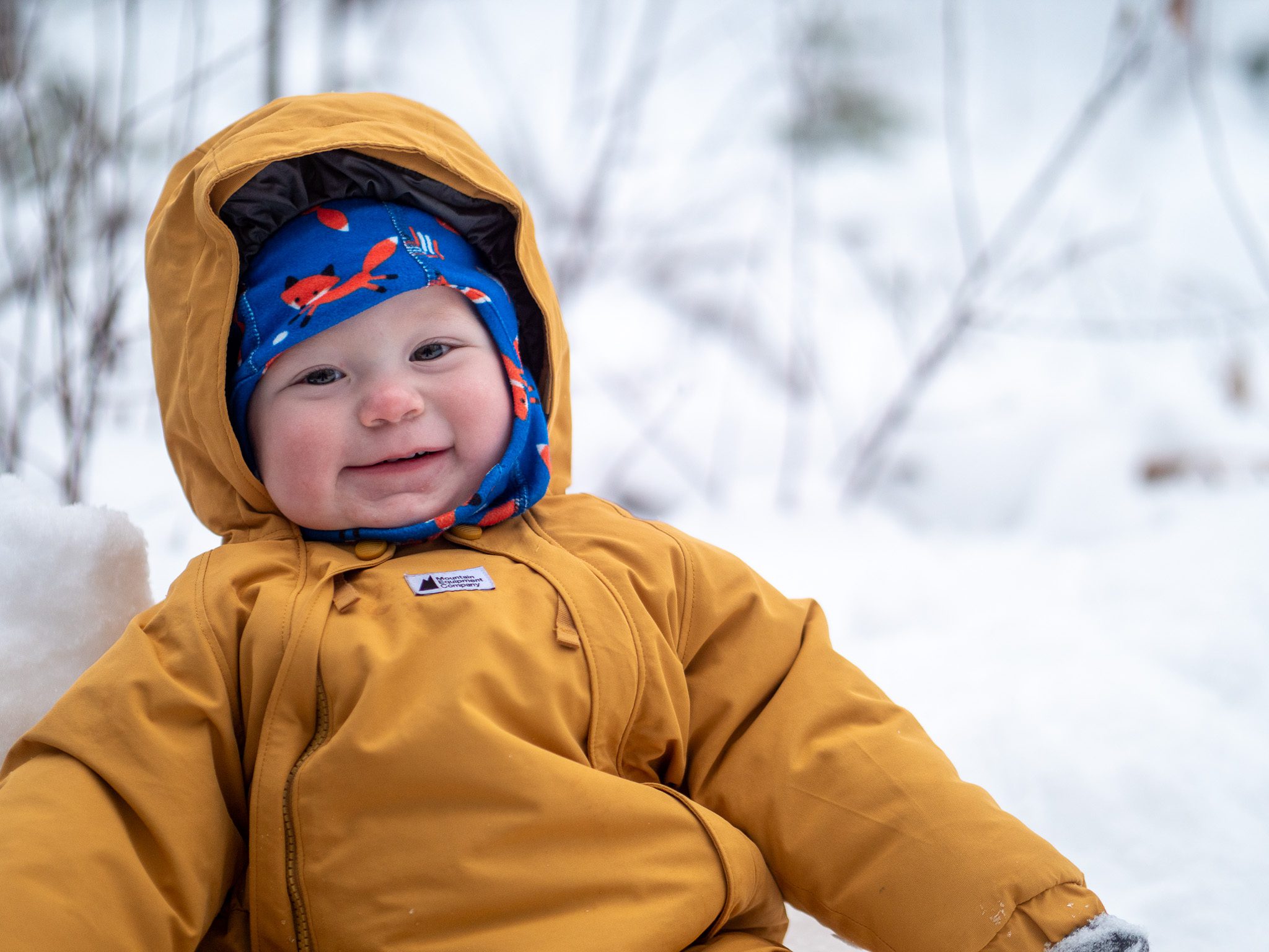 Family preparing winter travel gear for a bundled baby
