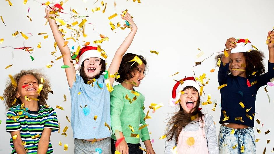 Happy kids throwing confetti during New Year's celebration
