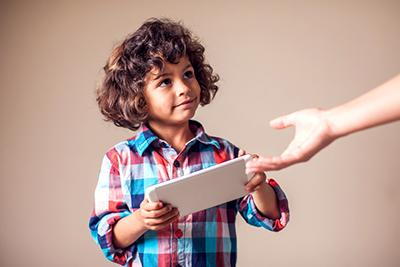 Child balancing screen time with creative offline activities